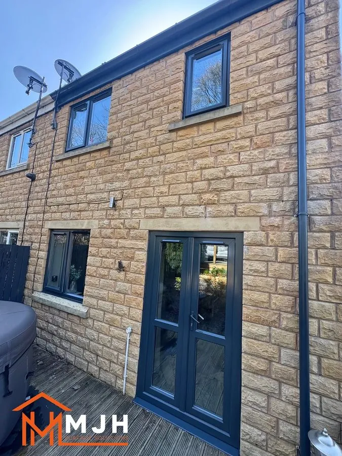 The same house with the windows and French doors sprayed anthracite