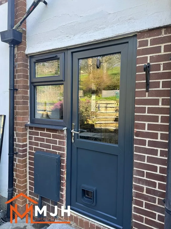 The same door and window sprayed anthracite against red brick