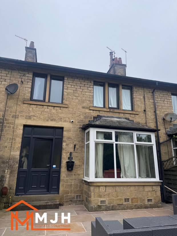 The same house before spraying, with a white uPVC bay window