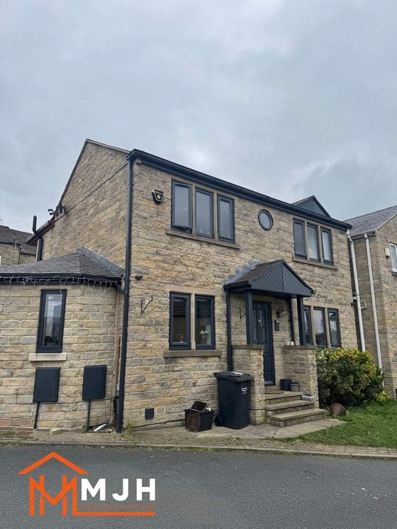 Stone detached house with windows, door, porch canopy, guttering and downpipes all sprayed anthracite grey