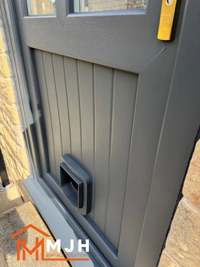 Close-up of the edge and letterplate of a sprayed grey door