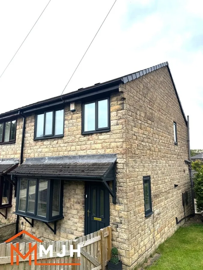 Gable end of a stone house with all frames sprayed anthracite