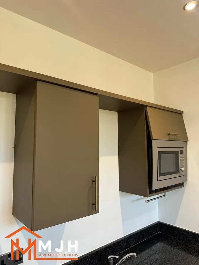 Sprayed kitchen wall units with an integrated microwave housing