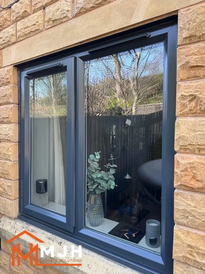 Large picture window sprayed anthracite grey in a stone wall